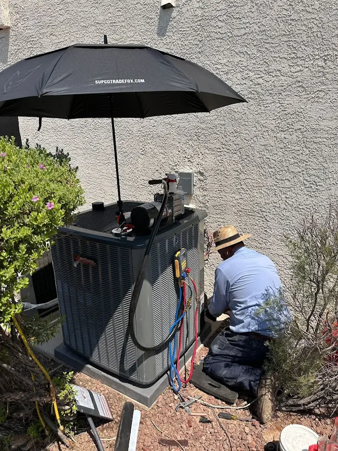 HVAC technician performing outdoor AC maintenance in Fort Meade