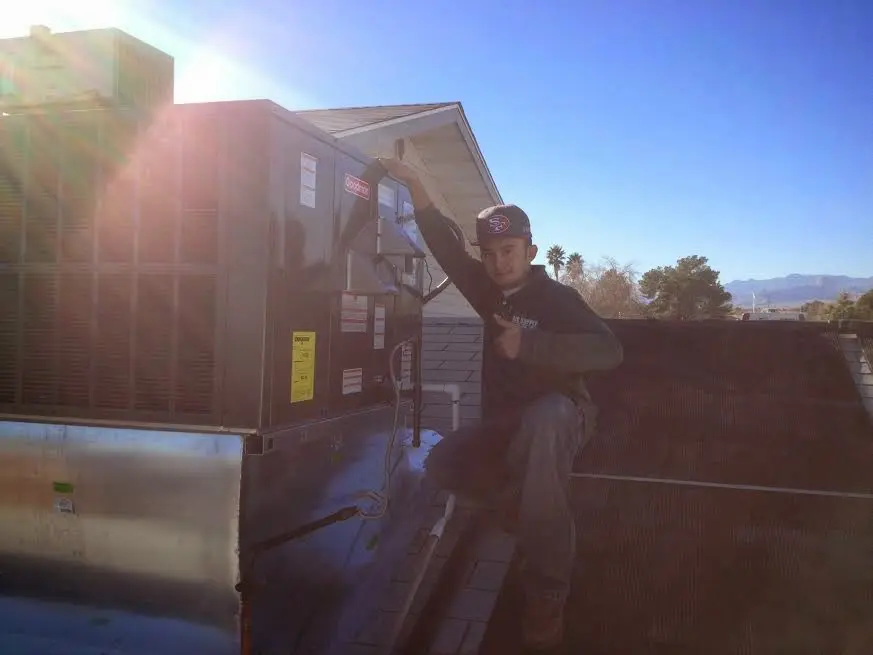 HVAC technician performing Heat Pump Repair on a rooftop unit in Fort Meade